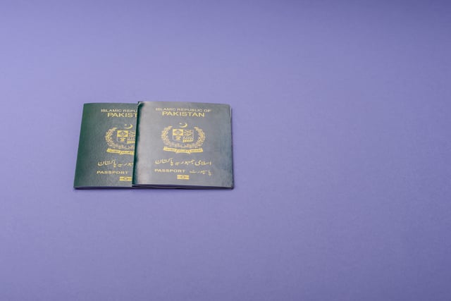 A couple of Pakistani passports on a purple background