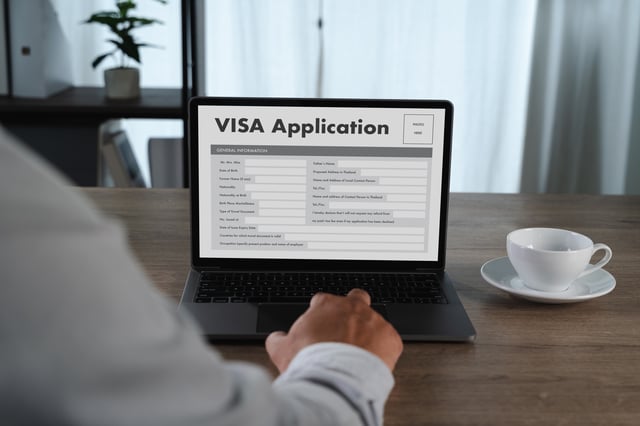 A Man signing up for a visa through his laptop