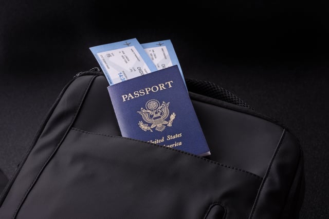 A Passport on top of a bag with two boarding passes