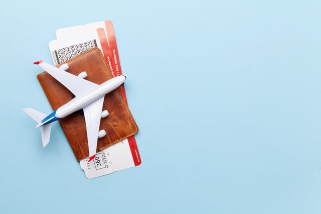A plane on top of some passports and boarding passes