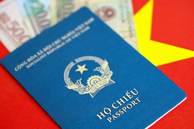 A Vietnamese passport on top of some Vietnamese currency
