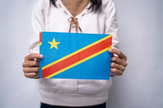 A woman holding the flag of the DRC
