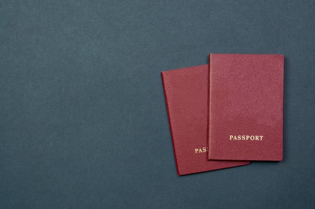 Image of two passports taken from above on a dark background