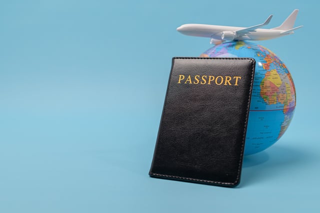 Passport next to a globe and plane