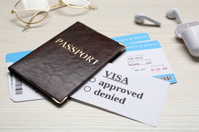 Passport on top of visa approval card and boarding passes