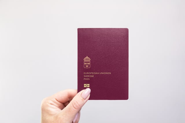 Person holding up a Swedish passport