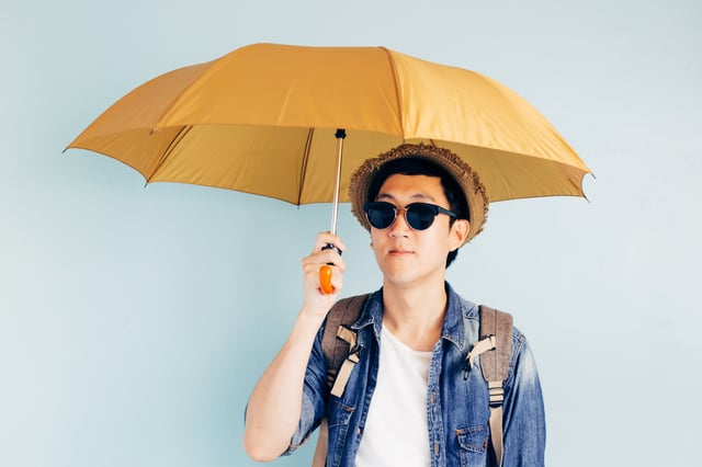 Tourist holding up an umbrella